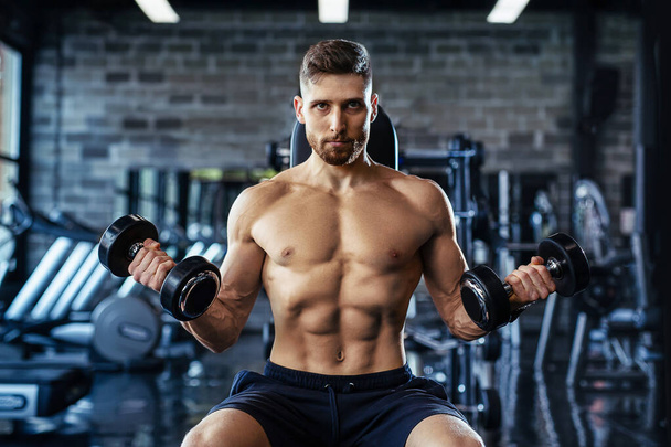 Muscular man during workout in the gym. - Foto, Bild