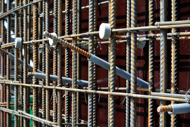 SELANGOR, MALAYSIA - 19.2015: Deformované ocelové tyče válcované za tepla nebo ocelová výztužná tyč a betonový rozpěrka. Mezera použitá k vytvoření mezery mezi výztužnou lištou a bedněním.   - Fotografie, Obrázek
