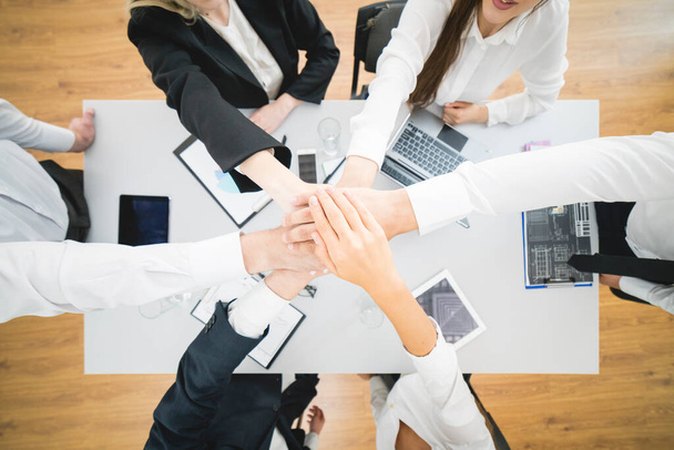 Шесть бизнесменов держатся за руки на фоне рабочего стола. вид сверху
 - Фото, изображение