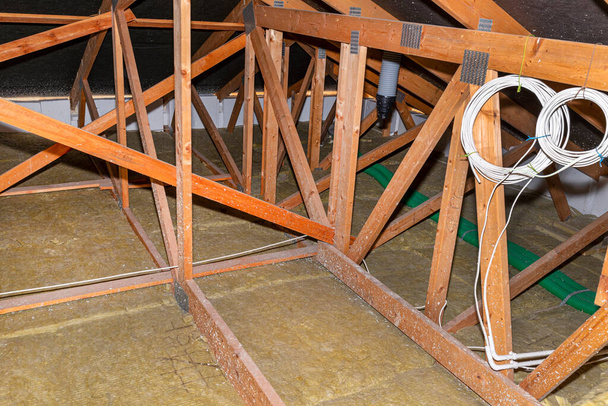 Isolation des plafonds et des greniers en laine de roche entre les fermes, extrémités visibles des tuyaux en plastique de ventilation
. - Photo, image