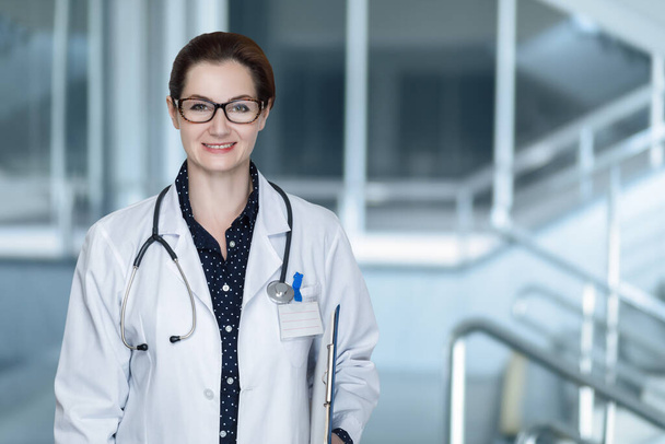 Doctor woman in glasses on a blurred background. - Φωτογραφία, εικόνα