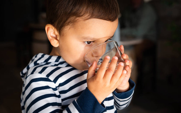 маленький мальчик пьет воду - Фото, изображение