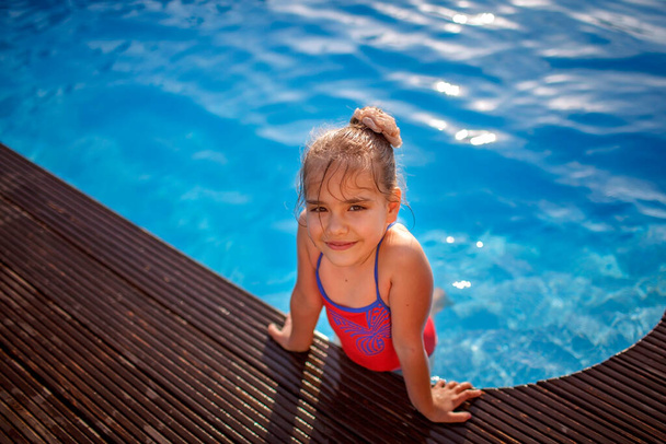 Familie weekend in zomerhuisje, lokale staycation. Schattig kind hebben een plezier en verkoeling in het zwembad op een warme dag, gelukkige zomertijd, outdoor lifestyle - Foto, afbeelding