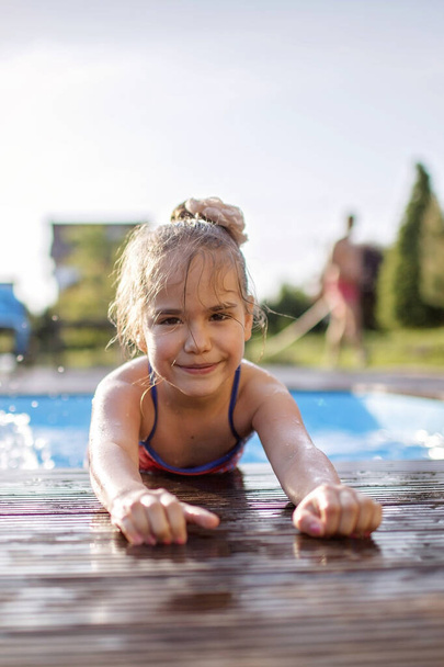 Week-end en famille en chalet d'été, séjour local. Enfant mignon s'amuser et se rafraîchir dans la piscine un jour chaud, été heureux, style de vie en plein air
 - Photo, image