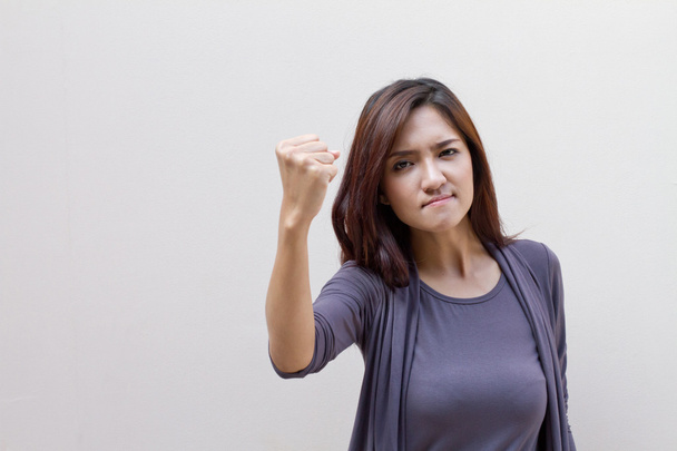 сердитая и агрессивная женщина, поднимающая кулак
 - Фото, изображение