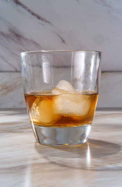 Whiskey jéggel kőben üveg a márvány konyhaasztalon - Fotó, kép