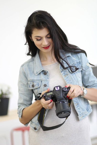 Belle giovani donne mantenendo la fotocamera professionale nelle sue mani - Foto, immagini