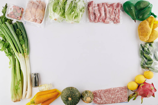 Voedsellevering achtergrond met verse rauwe groenten, gemalen vlees en steaks, uitzicht van boven - Foto, afbeelding