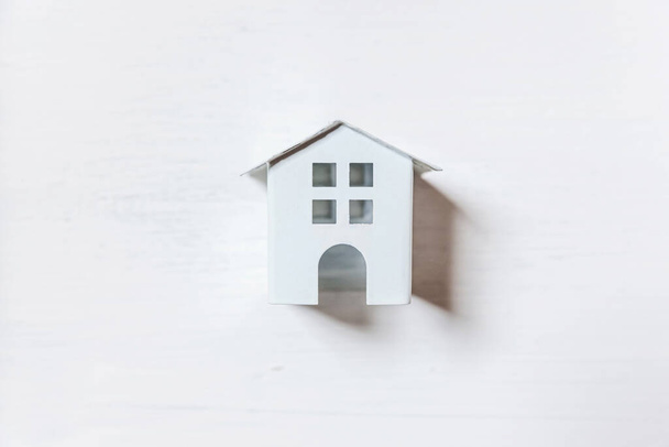 Einfach minimalistisches Design mit Miniatur-Spielzeughaus auf weißem Hintergrund. Hypothekenversicherungen träumen von einem Eigenheim. Flache Lageansicht Kopierraum - Foto, Bild