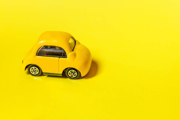 Simplement concevoir jaune vintage voiture rétro jouet isolé sur fond jaune coloré. Automobile et symbole de transport. Concept de livraison du trafic urbain. Espace de copie - Photo, image