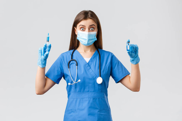 Covid-19 、ウイルス、健康、医療従事者および検疫の概念を防止する。ブルースクラブの興奮した女性看護師、注射器を保持する診療所の医師とコロナウイルスワクチンでアンプル - 写真・画像