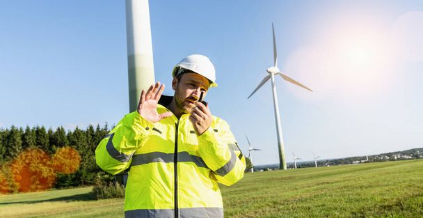 Engineer working a wind turbines, talking on the walkie-talkie for controlling work - Φωτογραφία, εικόνα
