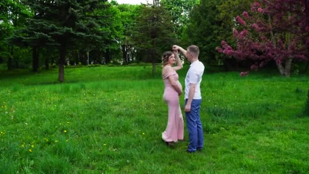 Un hombre con una mujer embarazada en un parque en primavera
 - Metraje, vídeo