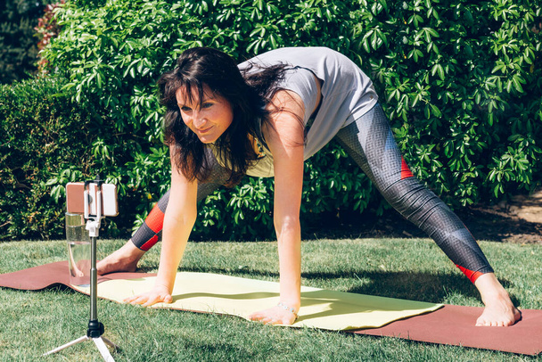 Donna sta facendo yoga in giardino
 - Foto, immagini