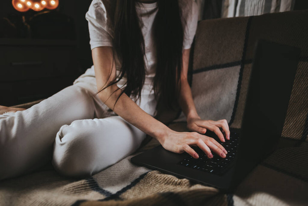 Woman is typing on a laptop keyboard, white screen.  - Фото, зображення