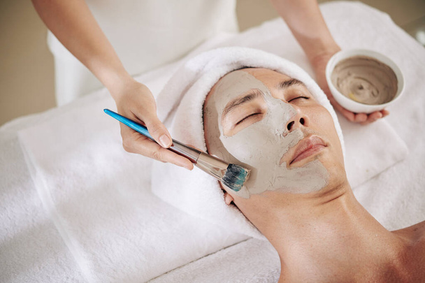 Asiatische Mann immer verjüngende und feuchtigkeitsspendende Hautbehandlung im Schönheitssalon - Foto, Bild