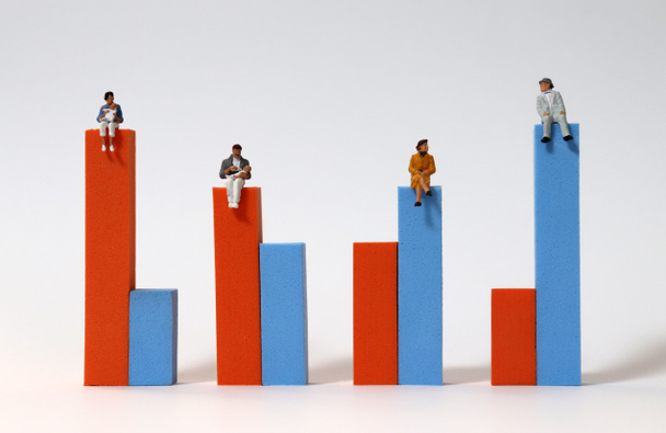 Miniature people sitting on a bar graph. - Photo, image