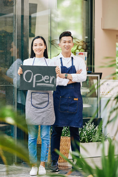 Joven pareja vietnamita feliz de abrir café después de largo período de cuarentena
 - Foto, Imagen