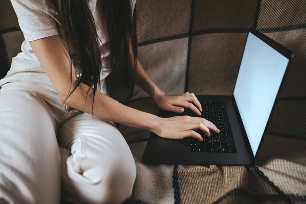 Woman is typing on a laptop keyboard, white screen.  - 写真・画像
