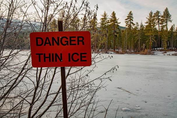 北カリフォルニアのラッセン火山国立公園のマンザニタ湖での薄い氷の警告標識.   - 写真・画像