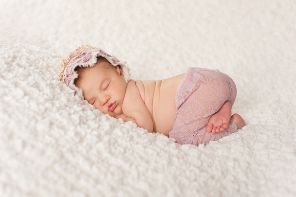 Retrato de una niña recién nacida con pantalones de encaje y capó
 - Foto, imagen
