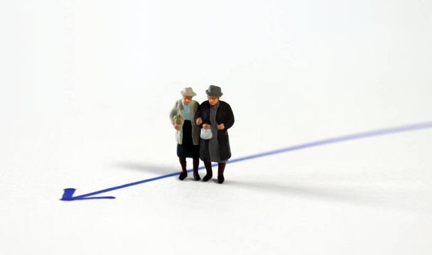 Miniature homosexual couple standing next to the blue arrow line. - Photo, Image