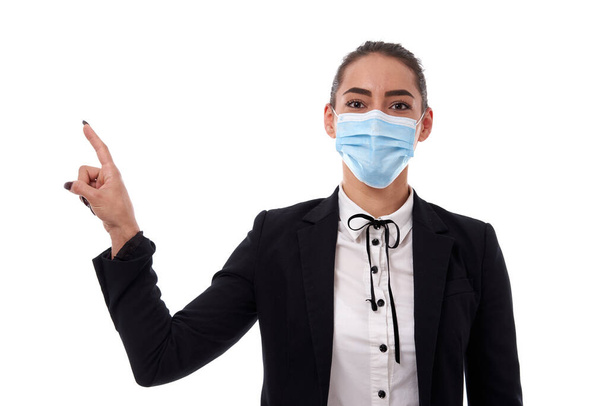 Young hispanic businesswoman in face mask pointing towards the copyspace, isolated on white background - Foto, afbeelding