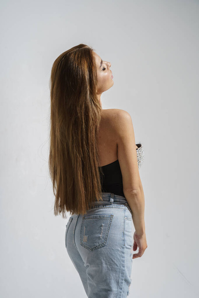 Stylish brunette in trendy clothes posing at studio on gray background   - Foto, Imagem