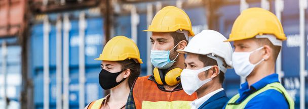 Teamwork engineer technician and foreman and partner wearing protection face mask and safety helmet in cargo container shipping area, Work successful. Crop image banner size. - Foto, afbeelding