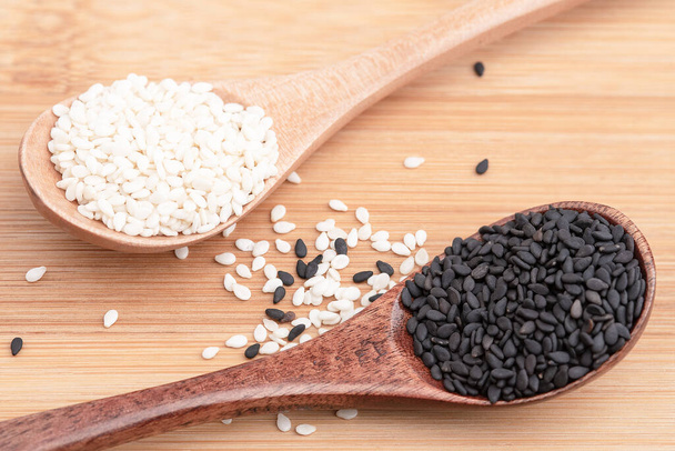 Bílá sezamová a černá sezamová semínka v dřevěné lžíci - Fotografie, Obrázek