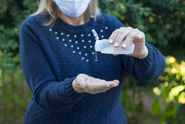 Mujer brasileña limpiándose las manos frotándose con gel desinfectante para prevenir el virus de la corona y el brote de gripe. Higiene para detener la propagación del coronavirus. Primer plano.
. - Foto, Imagen