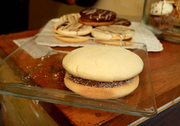 Alfajoresの閉鎖、伝統的なラテンアメリカのお菓子は、 Dulce de Lecheで満たされていますガラス板上で提供 - 写真・画像