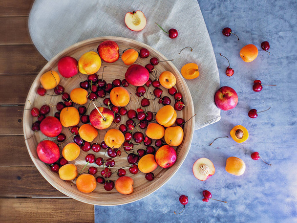 Peaches, apricots and cherries on a round platter - Valokuva, kuva