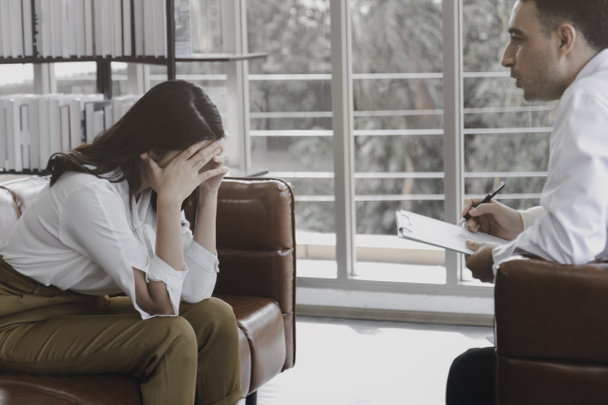Depressed patient having consultation with psychiatrist doctor, woman getting upset, feeling stressed and sad, need help from psychologist, mental health concept - 写真・画像