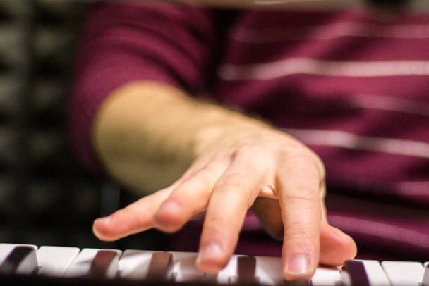 Nahaufnahme einer kaukasischen männlichen Hand, die eine Tastatur spielt, selektiver Fokus - Foto, Bild