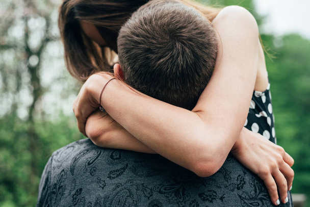 girl clasped hands on the neck of her boyfriend, hugging him - Foto, imagen