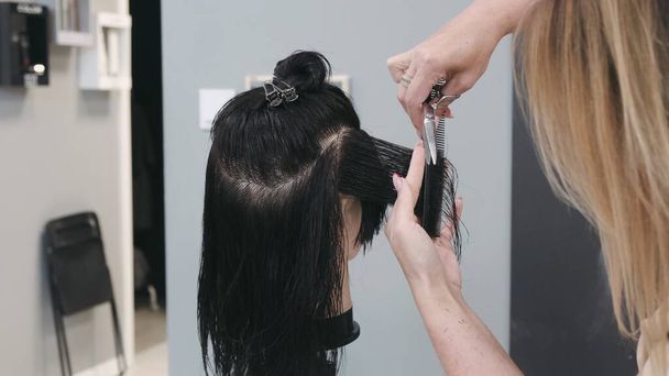 Stylist hair cutting with scissors on mannequin head, practices and training - Photo, Image