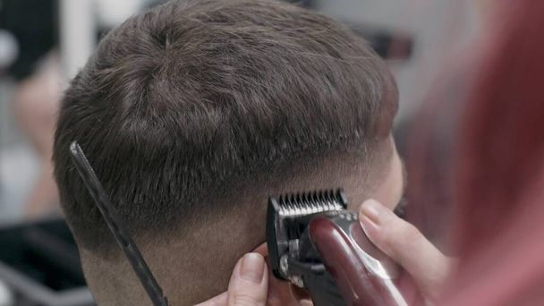 Haare schneiden mit Trimmer im Salon. Close up Kopf von Kerl mit trendigen Haarschnitt - Foto, Bild