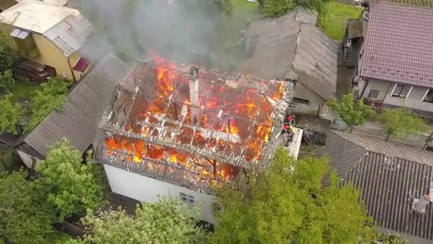 Luchtfoto van een huis in brand met oranje vlammen en rook. - Video