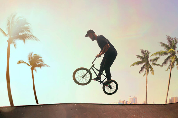 BMX-Fahrer zeigt bei Sonnenuntergang Tricks im Skatepark. - Foto, Bild