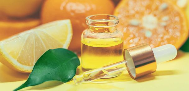 orange essential oil on a yellow background. Selective focus. - Foto, Bild