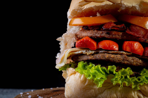 Großer hausgemachter Burger mit zwei Rindfleischburgern, Salat, Tomaten, Wurst, Schinken, Speck und Käse, AKA X-tudo in Brasilien - Foto, Bild