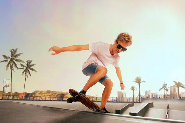 Skateboarder voert trucs uit in skatepark bij zonsondergang. - Foto, afbeelding