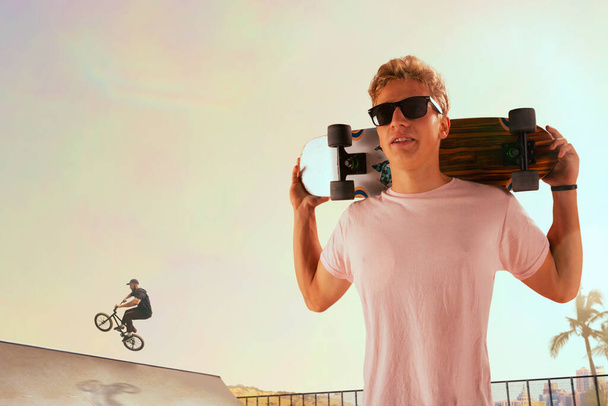 Скейтбордист исполняет трюки в скейтпарке на закате
. - Фото, изображение
