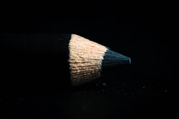 Μια μακρο-φωτογραφία από μια μαύρη μύτη μολυβιού. Κρατούσε σε σκοτεινό φόντο - Φωτογραφία, εικόνα