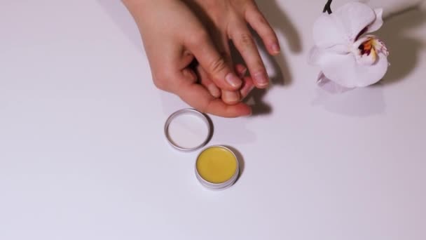 Dziewczyna wciera olejek woskowy w płytkę paznokcia. Wzmocnienie paznokci i pielęgnacji naskórka. - Materiał filmowy, wideo