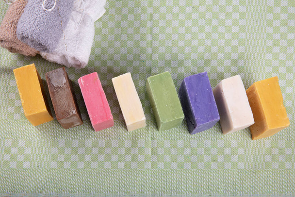 Kézzel készített szerves szappanok. Különböző típusú kézzel készített természetes szappan az asztalon, természetes szappan különböző alakú és színű, felülnézeti képek. - Fotó, kép
