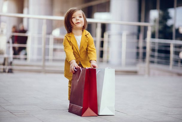 Cute little girl with shopping bag in a city - Foto, imagen