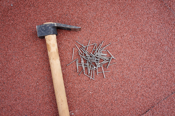 marteau avec clous sur bardeaux de toit rouge
 - Photo, image
