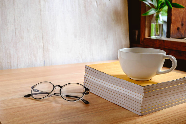 Καφές κύπελλο και βιβλίο με γυαλιά στο τραπέζι - Φωτογραφία, εικόνα